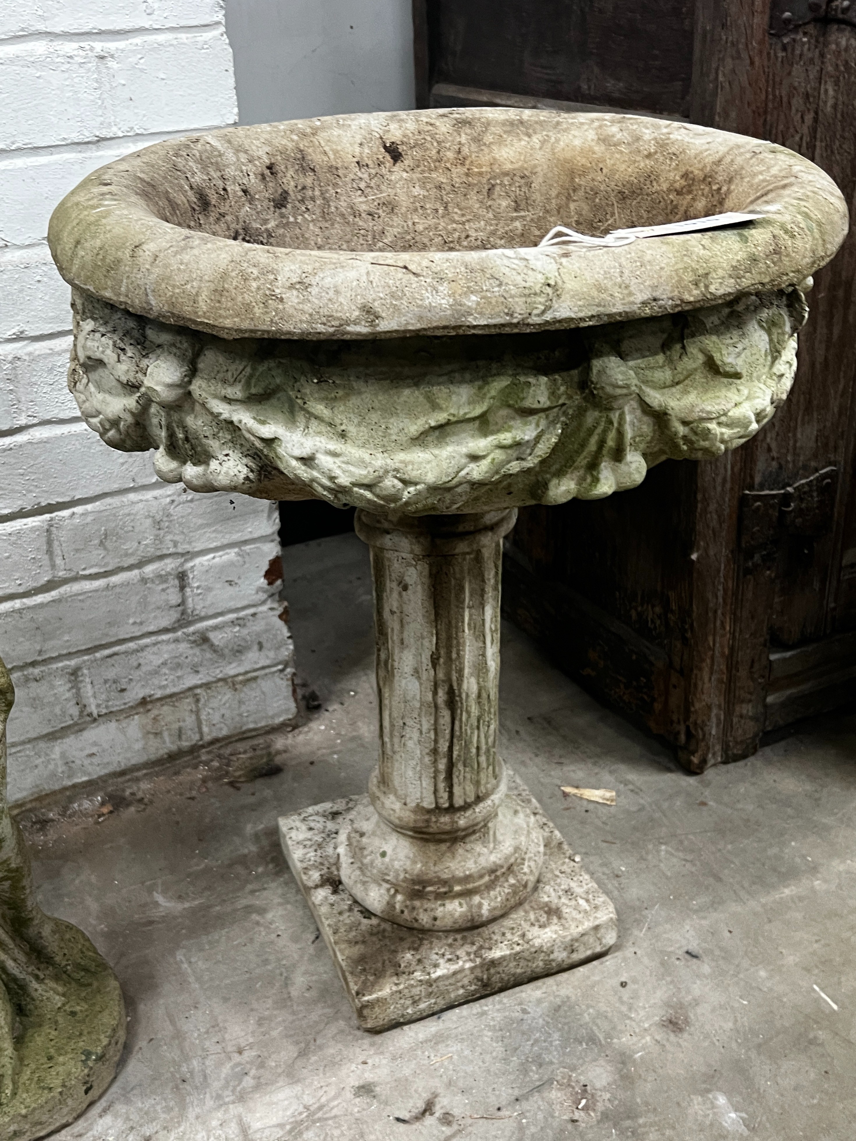 A reconstituted stone circular garden planter, width 49cm, height 65cm